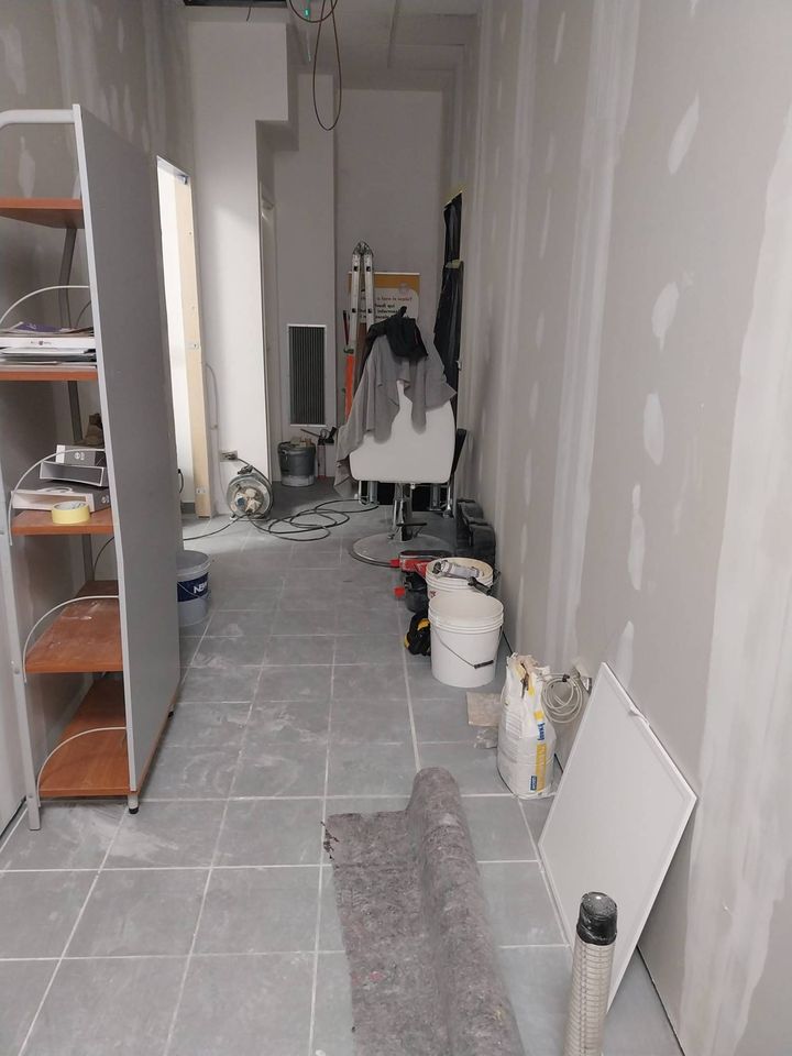 Corridoio con pareti in cartongesso e giunti stuccati, attrezzi e materiali di cantiere